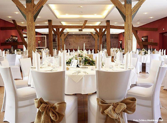 Liebevoll geschmückter Speisesaal in rustikal-modernem Ambiente mit weißer Dekoration und Blumengestecken