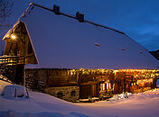 Traumhafte Schneelandschaft und der romantisch beleuchtete Hensler Hof bei Nacht