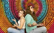 zwei meditierende Hippies vor bunter Wand