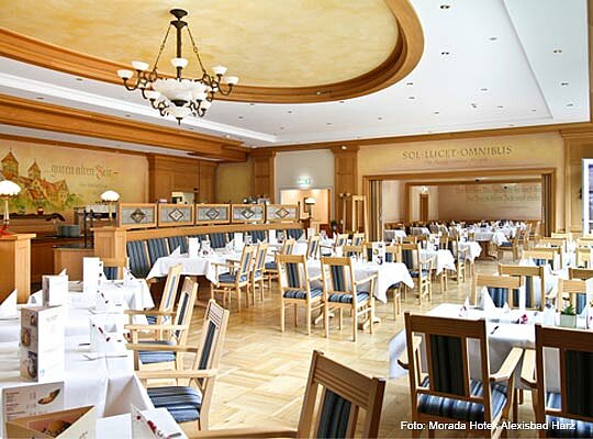 schöner Gastraum mit viel hellem Holz und Wandmalerei