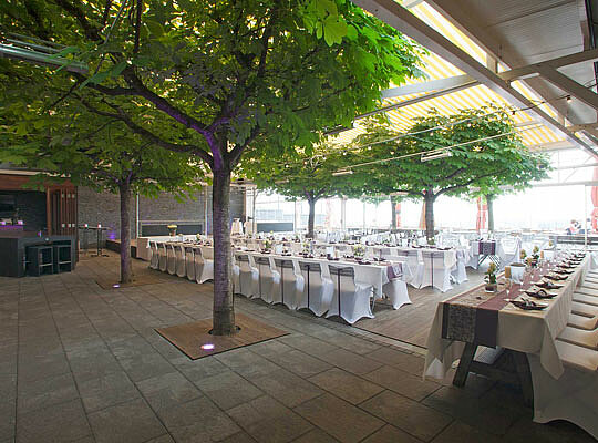 Mega Location beim Krimidinner Kressbronn im Max und Moritz Große Terrasse mit schönen Baumen und riesiger Jalousie und feierlich angerichteten Esstischen