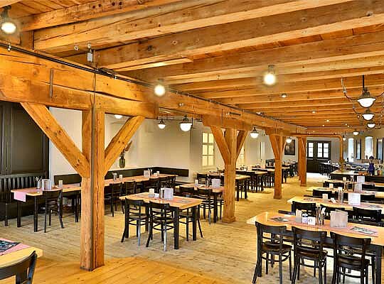 Krimidinner Kulmbacher Kommunbraeu Uriger Saal mit Holztischen. Brauereiatmosphäre beim Krimidinner