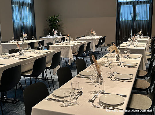 Langer Tisch, welcher für ein Dinner gedeckt ist.