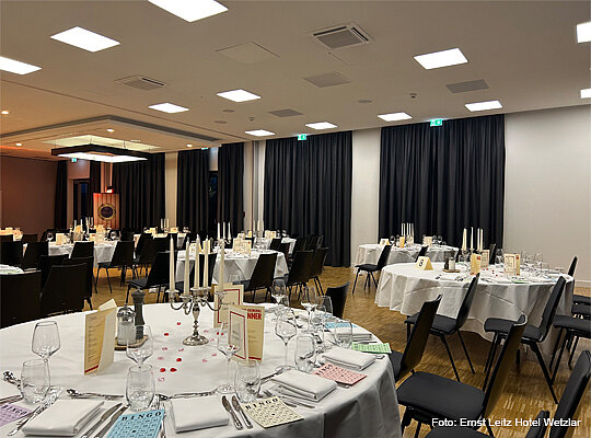 festlicher Veranstaltungssaal mit großen runden Tischen