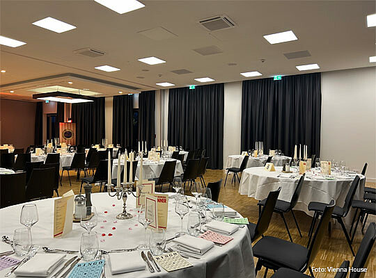 festlicher Veranstaltungssaal mit großen runden Tischen