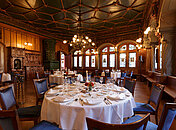 Historischer, gemütlicher Saal mit Holzverkleidung und festlichen Tischen im Zunfthaus zur Schmiden beim Krimidinner Zürich