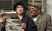 Zwei Personen lesen erschrocken eine Zeitung