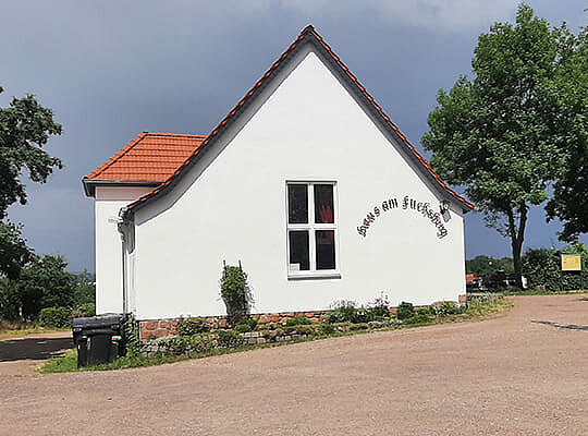 Krimidinner Halle (Saale) in der Gaststätte Haus am Fuchsberg Blick vom Hof auf die moderne, weiß gestrichene Gaststätte