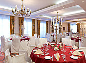 Großer Speisesaal mit rot dekorierten, runden Tischen. Angerichtet für das Kriminal Dinner Gotha.