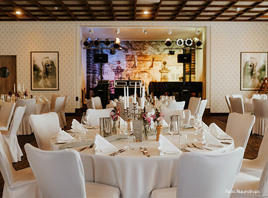 große, festlich eingedeckte Tafel mit großem Kerzenständer