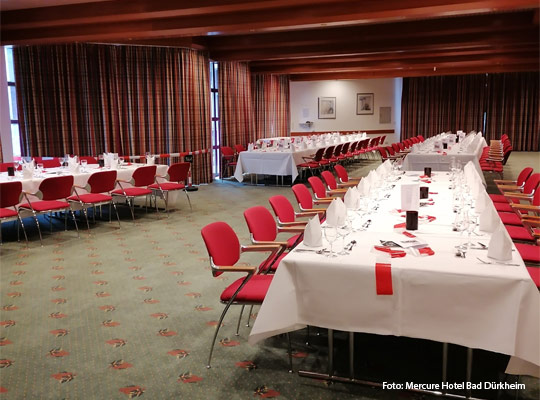 gedeckte Tafeln im großzügigen Veranstaltungsraum