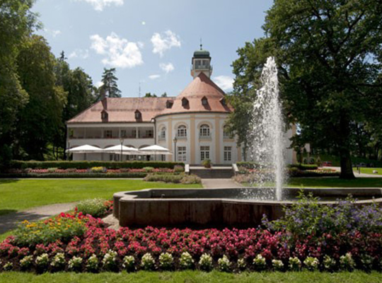Historisches Gebäude mit schöner Grünanlage und Sprinbrunnen im Kurhaus Bad Tölz