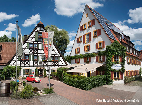 Außenansicht des Hotel & restaurant Lohmühle, in form eines Fachwerkshauses mit einer Gepflasterten Einfahrt