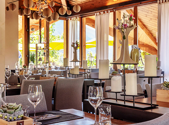 Stilvoll gedeckte Tische im Innenraum des Restaurants Klein Waldegg mit großen Lichtdurchfluteten Fenstern