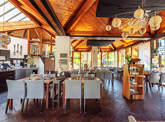 Lichtdurchfluteter, chic dekorierter Speisesaal mit schöner Holzdecke