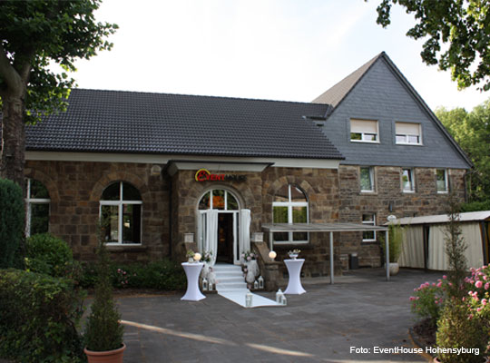 Frontansicht des Steinhauses mit weißem Teppich vor dem Eingang