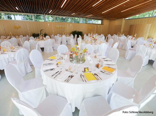 festlich gedeckter Speisesaal mit großen runden Tischen