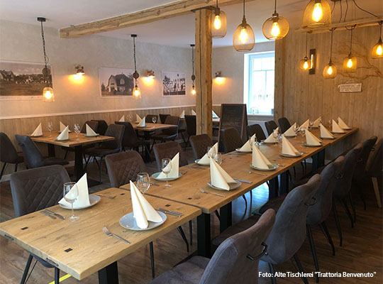 Lange Tischtafel, gedeckt mit Tellern und Servietten
