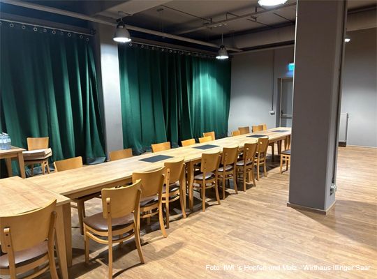 Veranstaltungssaal mit Blick auf die Bühne mit grünem Samtvorhang