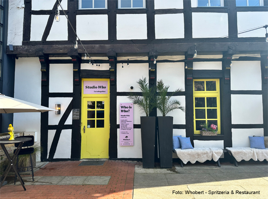 Außenansicht der Fachwerkfront mit gelber Türe und Fensterrahmen