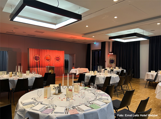festlicher Veranstaltungssaal mit großen runden Tischen