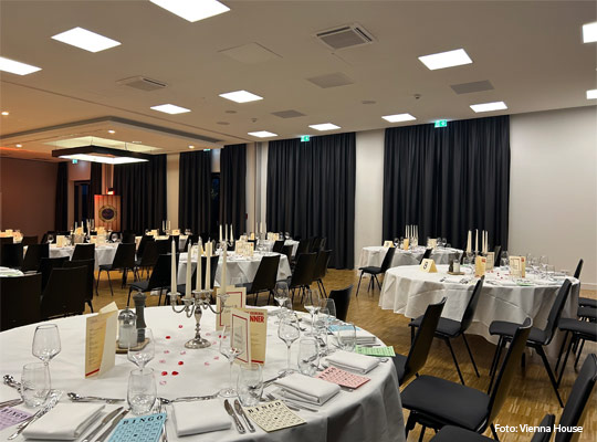 festlicher Veranstaltungssaal mit großen runden Tischen