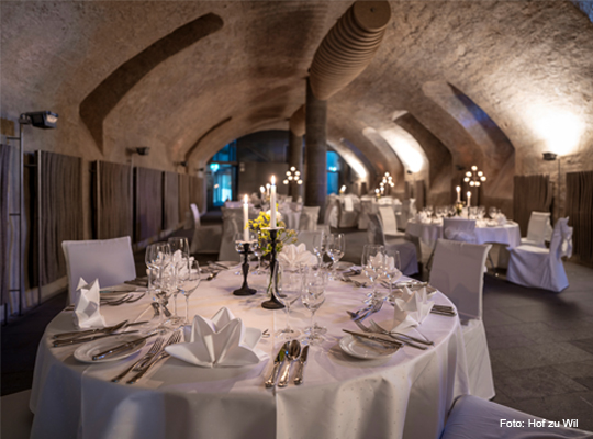 elegant gedeckter, runder Tisch im Gewölbekeller