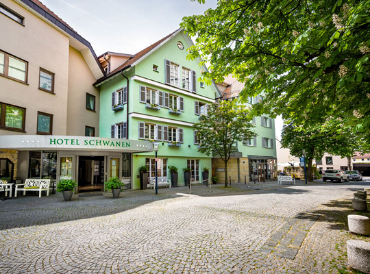 Einladend gestalteter Eingangsbereich des Hotelgebäudes bei bestem Wetter 