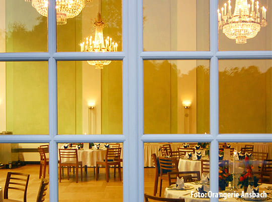 Blick durch die großen Fenster in den gelblich noblen Speisesaal
