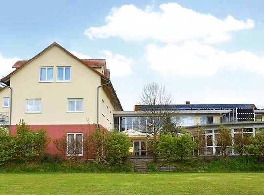 Außenansicht des Hotel-Restaurant-Gebäudes von der schönen grünen Wiese beim Terrassenbereich 