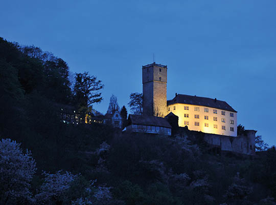 Blick auf die beleuchtete Burg Guttenberg bei Dunkelheit
