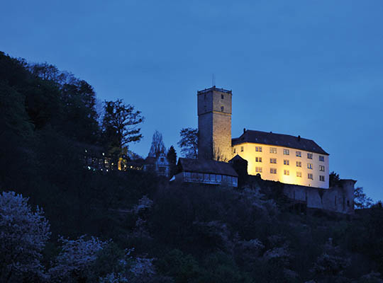 Blick auf die beleuchtete Burg Guttenberg bei Dunkelheit