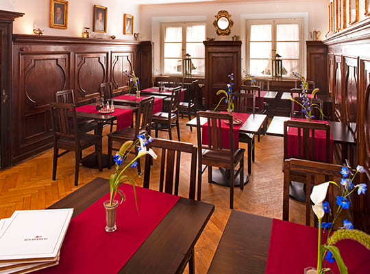 Liebevoll eingerichteter Speisesaal mit Holzfassade und gemütlichen Sitzgelegenheiten.