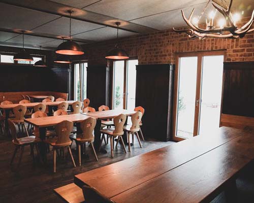 frisch renovierter Restaurantbereich mit warmen Holztönen und modernen Deckenlampen.