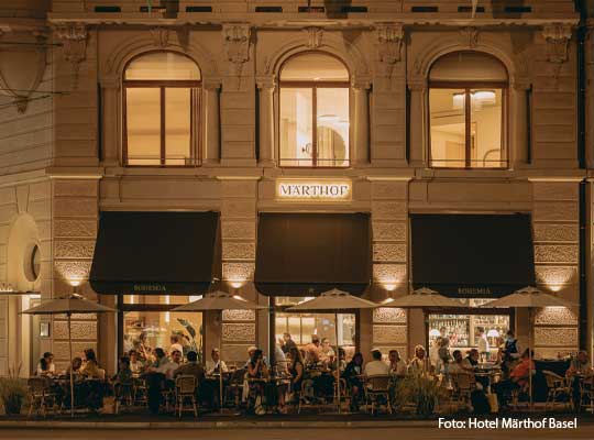 Alte Steinfassade beleuchtet bei nacht vom Märthof in Basel