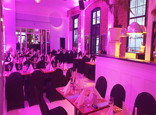 Ein mit lilafarbenen Licht beleuchteter Raum mit einer Bar 