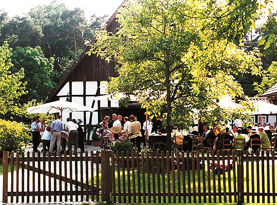 Feiernde Menschen im Außenbereich des Gasthauses Buschkamps bei schönstem Wetter im Grünen.