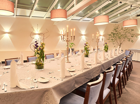 Hell beleuchteter Raum mit Tischen und Stühlen, die mit weißen Details dekoriert sind