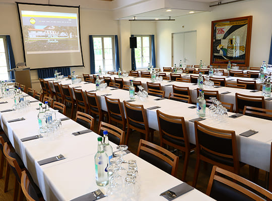 Großer Speisesaal mit langen Tischreihen angerichtet für ein spannendes Krimidinner.