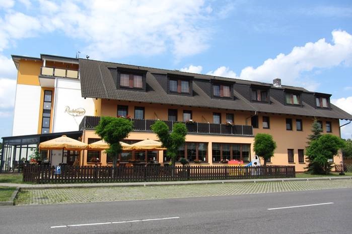 Modernes Hotel & Restaurant mit beiger Außenfassade und schöner, einladender Terrasse.