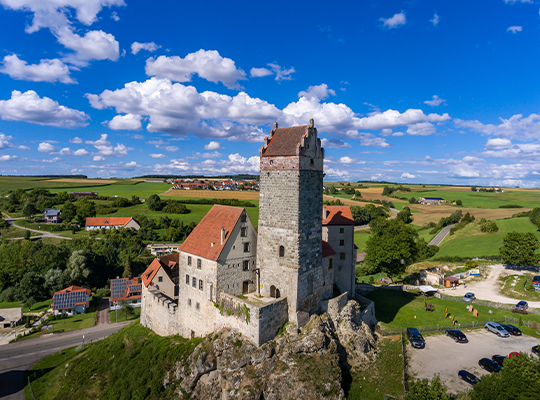 Blauer Himmel, grüne Wiesen und die Burg, die in den Himmel ragt