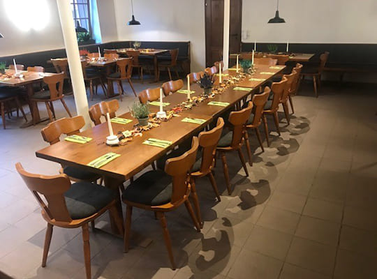 Lange Tischtafel in der Mitte des Speisesaals inklusive gemütlichen Eckbänken außenrum