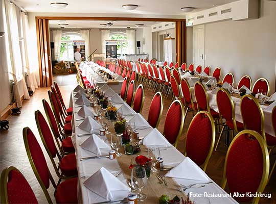 Saal mit rot-goldenen Stühlen und Tischdeko beim Krimidinner Flensburg