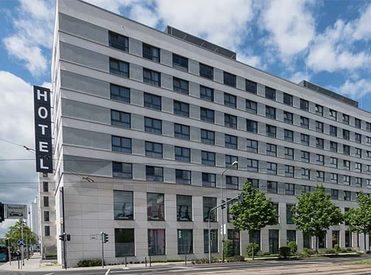 Großes Hotelgebäude an der Straße bei blauem Himmel.