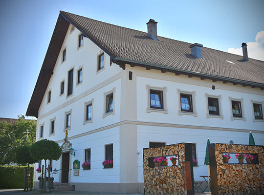 Außenansicht des einladenden Eingangs des Gasthof beim Alten Wirt an einem wunderschön sonnigen Tag