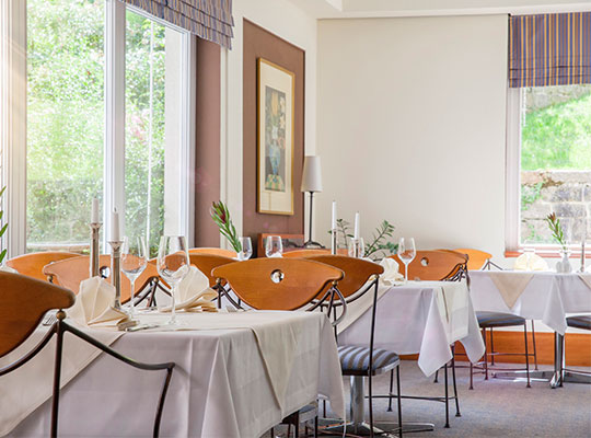 Restaurant mit großen Fenstern, Tische und Stühle aus Holz