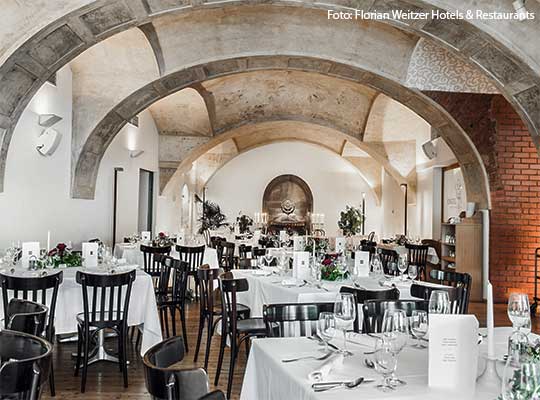 Imposantes Restaurant von innen, eingedeckt mit weißen Tischdecken und hochwertigem Porzellan