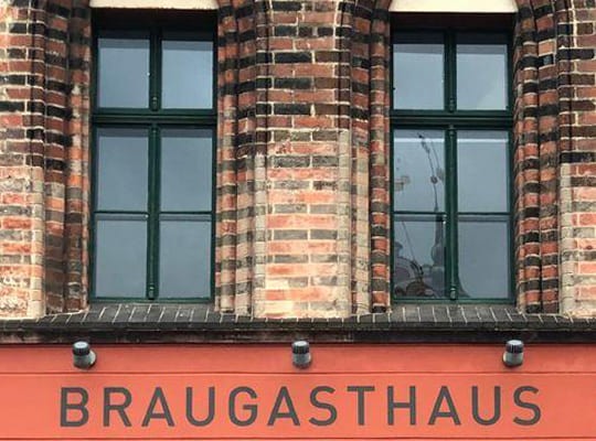 Außenansicht des historischen Braugasthaus-Schriftzugs über dem Eingangsbereich