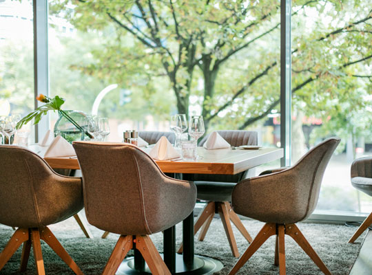 gedeckte Tische im modernen Gastraum des Arcotel Rubin unserer Krimidinner Hamburg Location