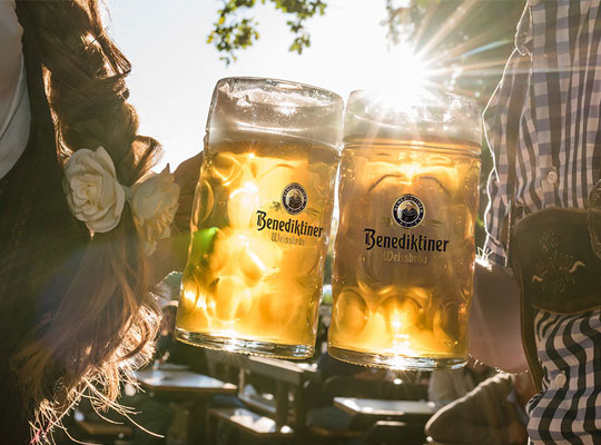 Biergarten in welchem Menschen mit einem Bier anstoßen